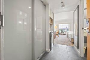 a hallway with a glass door leading to a bedroom at Top Floor Studio with Balcony & Views 3528 in Honolulu