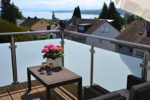 een tafel met een vaas met bloemen op een balkon bij Ferienwohnung Am Bergle in Überlingen