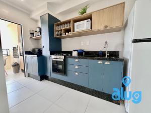 a kitchen with blue cabinets and a microwave at S1703T1 Vista Mar | Sacada Gourmet | Beto Carrero in Penha
