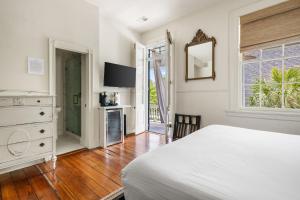 a bedroom with a bed and a dresser and a mirror at The Ashley Veranda King Suite includes Breakfast in Charleston +16 photos