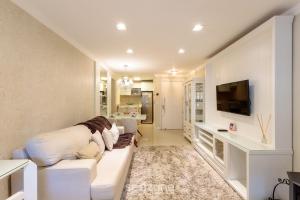 a living room with a white couch and a tv at Apto Aconchegante no Centro de Canela | CPL025 in Canela
