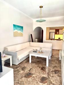 a living room with a white couch and a table at Rosie Apartment in Preveza +4 photos