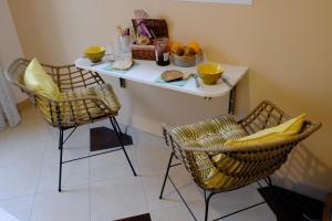 a table with two chairs and a table with food on it at Chambre indépendante avec vue sur mer et marais du littoral, Salle de bain et WC privatifs , kitchenette et terrasse partagées in Fontenay-sur-Mer