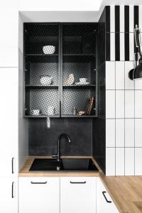 a kitchen with white cabinets and a sink at Neptun Park Premium by NorthSide Apartments in Gdańsk
