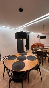 a dining room with tables and chairs and a couch at Apartamento moderno, e aconchegante em Icaraí! in Niterói