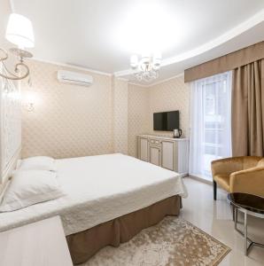 a bedroom with a bed and a couch and a television at Arcadia Gold in Odesa