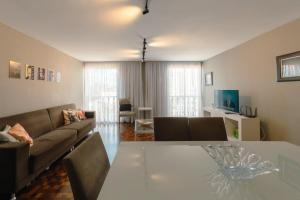 a living room with a couch and a table at Apartamento Central Aconchegante e Espaçoso SQ53 in Maringá