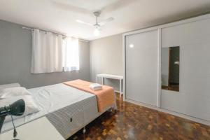 a bedroom with a bed and a large window at Apartamento Central Aconchegante e Espaçoso SQ53 in Maringá