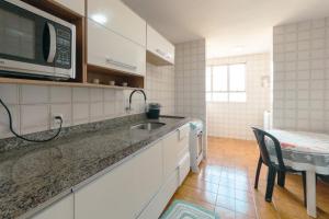 a kitchen with a sink and a microwave at Apartamento Central Aconchegante e Espaçoso SQ53 in Maringá +24 photos
