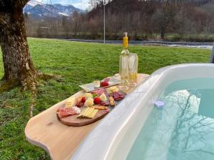 a tray of food and a bottle of wine next to a swimming pool at Glarner Spa I Private Sauna & Hot Tub & Alps View in Ennenda
