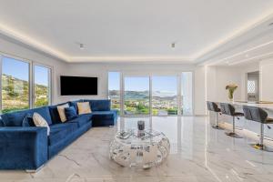 a living room with a blue couch and a table at Sea View Residence Panorama Villa in Saronida