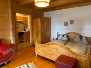 a bedroom with a wooden bed and a kitchen at Berggasthof Ferienhaus Gut Lichtenau in Hauzenberg