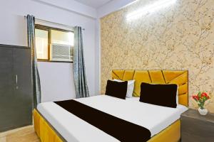 ニューデリーにあるHotel O K. P. Luxuriosのベッドルーム1室(黄色のヘッドボード付きのベッド1台付)