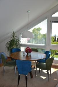 een eetkamer met een houten tafel en blauwe stoelen bij Ferienwohnung Am Bergle in Überlingen
