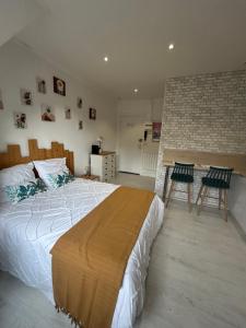 a bedroom with a large bed and two chairs at Studio Miscanthus Vauban in Lorient