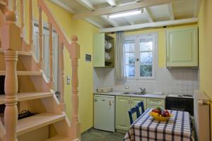 a kitchen with a table with a bowl of fruit on it at Aretousa Studios & Apartments in Skopelos Town