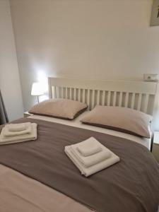 twee witte handdoeken bovenop een bed bij A&Z APARTMENT in Zagreb
