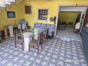 a living room with a table and chairs and a couch at Kitão Completo ao lado da Balsa Bertioga in Bertioga