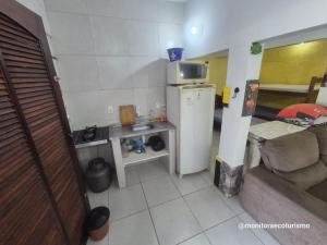 a small kitchen with a refrigerator and a couch at Kitão Completo ao lado da Balsa Bertioga in Bertioga +8 photos