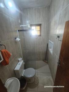 a small bathroom with a toilet and a shower at Kitão Completo ao lado da Balsa Bertioga in Bertioga