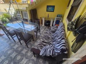 a room with two zebras laying on the floor with a table at Kitão Completo ao lado da Balsa Bertioga in Bertioga
