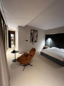 a bedroom with a bed and a chair in it at شاليهات اصالة فيلا الفندقية in Buraydah +24 photos