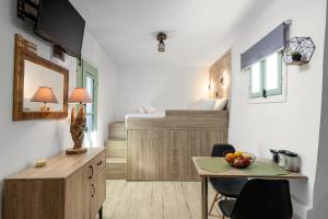 a room with a desk and a bed and a table at MANOS Small House Kouremenos in Palekastron