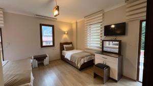 a hotel room with a bed and a flat screen tv at Valoria Hotel in Uzungöl