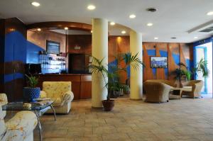 una hall con divani e piante in un edificio di Hotel Sirenetta a Isola delle Femmine