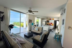 un salon avec un canapé et un ventilateur de plafond dans l'établissement Hermosa casa con vista al mar en Jama Campay, à Los Camarones