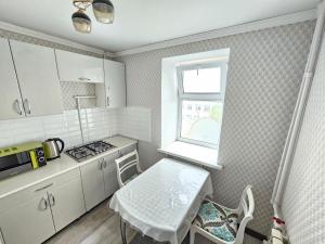 a small kitchen with a table and a window at Mars APARTMENTS KZ 1 in Aktobe