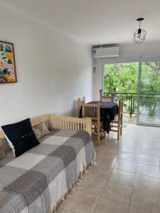 een slaapkamer met een bed en een tafel en een balkon bij Monoambiente cris in Colón