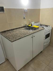 een keuken met een spoelbak en een fornuis bij Monoambiente cris in Colón