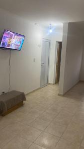 een woonkamer met een flatscreen-tv aan de muur bij Monoambiente cris in Colón