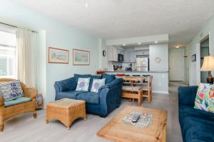 un soggiorno con un divano blu e un tavolo di Yerby by Bryant Real Estate a Kure Beach