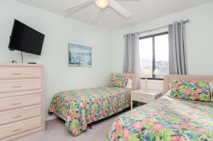 una camera da letto con due letti e una TV a schermo piatto di Yerby by Bryant Real Estate a Kure Beach Altre 39 foto