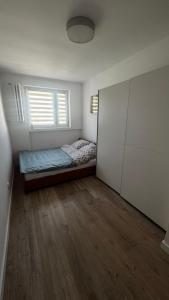 ein kleines Schlafzimmer mit einem Bett und einem Fenster in der Unterkunft EG Apartments in Lublin