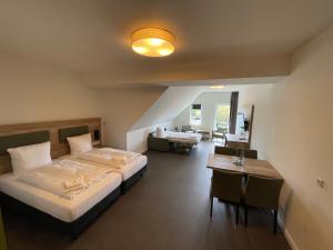 a hotel room with two beds and a desk and a room at Hotel am Pferdemarkt in Aurich +57 photos