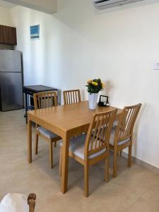 a wooden dining room table with chairs and a vase with flowers at Cozy 2-Bedroom Beach Flat in Paralimni +2 photos