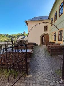 un edificio con mesas y bancos delante de él en Apartmán Akademik, en Banská Štiavnica
