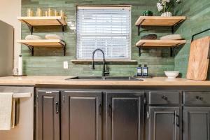 eine Küche mit Spüle und Holzregalen an der Wand in der Unterkunft Fort Worth Cottage Retreat in Fort Worth + 62 Fotos