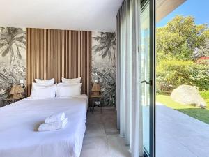 Un dormitorio con una cama con dos almohadas encima. en L'Alivetu Villa #INDENO, en Porto Vecchio