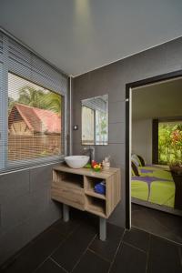 a bathroom with a sink and a bed and a mirror at Villa Vaihere in Orufara