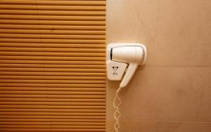 a hairdryer on the side of a wall at Sand Vibe RIN Grand Hotel in Bucharest