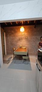 a table and chairs in a kitchen with a wall at Casinha da Paz in Praia Grande