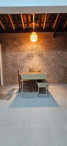 a table and bench in a room with a wall at Casinha da Paz in Praia Grande