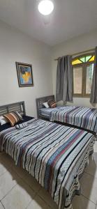 two beds sitting next to each other in a bedroom at Casinha da Paz in Praia Grande