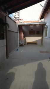 a shadow of a person standing outside of a building at Casinha da Paz in Praia Grande