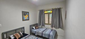 a bedroom with a twin bed and a window at Casinha da Paz in Praia Grande +7 photos