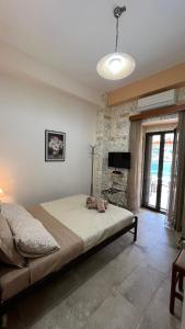 a bedroom with a bed in a room with a stone wall at MiloPetra in Gerolimenas